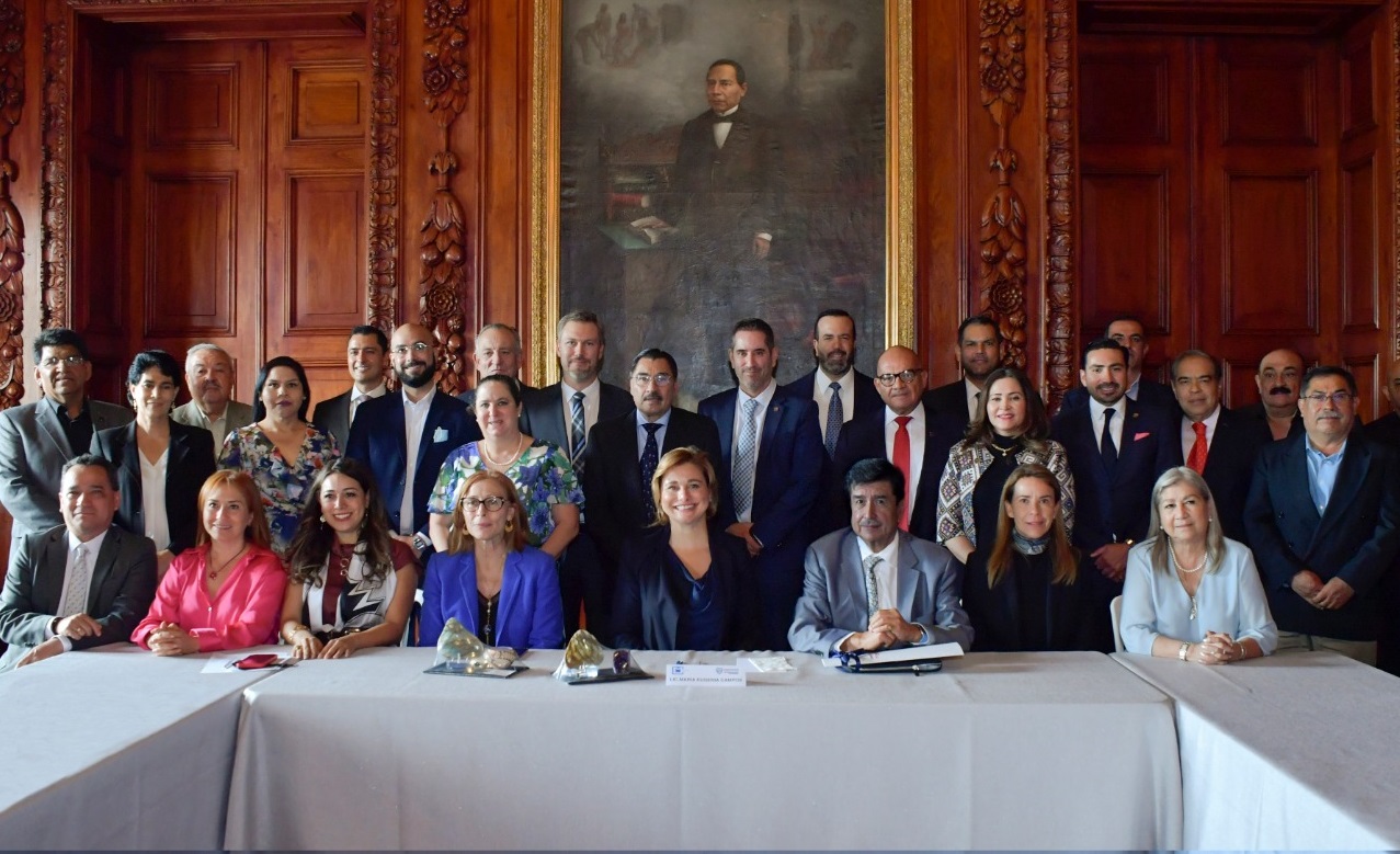 La gobernadora del Estado de Chihuahua, Maru Campos Galván dio la bienvenida al Consejo de la Cámara Minera de México (CAMIMEX), mismo que sesionó en la capital del Estado, para así, desde el Gobierno del Estado poder impulsar la vocación minera de Chihuahua y contribuir al desarrollo económico de nuestra entidad en atención a una de las acciones prioritarias plasmadas en el Plan Estatal de Desarrollo. En compañía de la secretaría de Innovación y Desarrollo Económico, María Angélica Granados Trespalacios y el secretario de Seguridad Pública del Estado, Gilberto Loya Chávez, la Gobernadora recibió a José Jaime Gutiérrez Núñez, presidente de la CAMIMEX y a Karen Lucía Flores Arredondo, directora general de la misma; así como a la secretaria de Economía del Gobierno Federal, Tatiana Clouthier Carrillo, para llevar a cabo la sesión del consejo de esta Cámara y así posicionar a Chihuahua en la agenda de acciones a atenderse por parte de la Cámara Minera. La gobernadora Maru Campos celebró la histórica vocación minera del país y destacó que Chihuahua cuenta con inversiones muy importantes en el sector minero, de las cuales se desprenden más de 20 mil empleos directos y 100 mil más de forma indirecta. Comentó que para el sector minero, lo más importante es ofrecer gobernabilidad y certeza jurídica de que la industria prospere y a quienes se emplean, puedan vivir de la mejor manera con el aseguramiento y atracción de inversiones, por lo que a través del modelo de gobernanza de la Cuádruple Hélice que impulsa esta administración estatal, se refrenda el apoyo del Gobierno con la industria minera con respeto al ámbito federal, así como el respeto al medio ambiente y el estatus laboral de los chihuahuenses. “Tengamos claro que si al sector minero le va bien; por ende la irá bien a Chihuahua”, comentó Campos Galván al ofrecer su apoyo a la CAMIMEX y al Gobierno Federal para el desarrollo de la minería y subrayó que a siete meses del inicio de esta nueva administración, ya se cuenta con casos de éxito que se plasman en materia de seguridad a este sector, como la reciente liberación de una mina en el municipio de Parral la cual fue bloqueada por un transportista y en un lapso de 12 horas, la SSPE, encabezada por Gilberto Loya, logró la liberación de la misma. Por su parte, la secretaria de Economía del Gobierno Federal, Tatiana Clouthier comentó que existe la necesidad de romper mitos con ejemplos positivos los cuales deben ser extendidos y replicados, tal es el caso del trabajo de una mina ubicada en el municipio de Ocampo, con la que quedó impresionada por su valía. Karen Lucía Flores Arredondo; directora general de CAMIMEX explicó que esta cámara representa los intereses de la industria minera y metalúrgica del país y actualmente albergan 125 unidades operativas que representan más del 90 por ciento del valor de la minería de nuestro país y es la quinta actividad económica generadora de divisas del territorio nacional. Flores Arredondo destacó que Chihuahua, está dentro de los 3 estados que aportan el 82 por ciento del valor de la industria minera, además de ser el segundo mayor productor de plata y el tercero en oro del país, por tal motivo, se tiene presencia de esta cámara en 123 localidades dentro de 27 municipios del Estado con lo que se genera más de 120 mil empleos directos e indirectos en el territorio estatal.